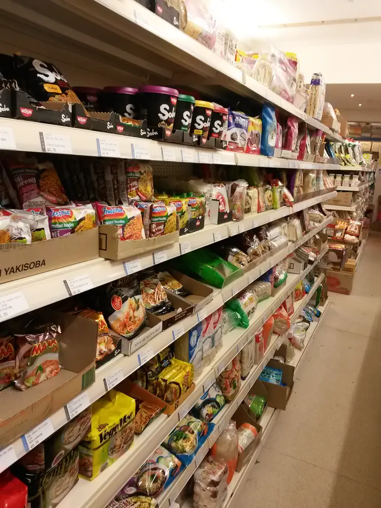 Supermarket aisle stacked with Nissin Soba, Indomie and MAMA instant noodle packets